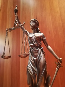 Statue of blindfolded Justice, holding scales and the sword of truth.